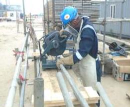 Bolpex technician cutting pipe on site in full PPE